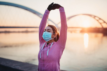 Beautiful young and fit woman in good shape running and jogging alone on city bridge street. She...
