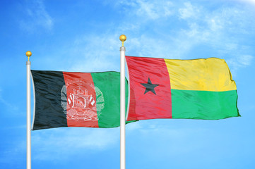 Afghanistan and Guinea-Bissau  two flags on flagpoles and blue cloudy sky