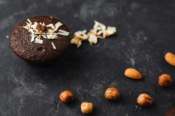 Chocolate cupcakes, muffins with banana and nuts, on a black table and a dark background. Top view, side view. Close-up and medium plan. Space for text.