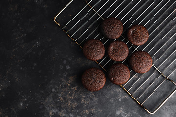 Chocolate cupcakes, muffins with banana and nuts, on a black table and a dark background. Top view, side view. Close-up and medium plan. Space for text.