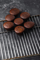 Chocolate cupcakes, muffins with banana and nuts, on a black table and a dark background. Top view, side view. Close-up and medium plan. Space for text.