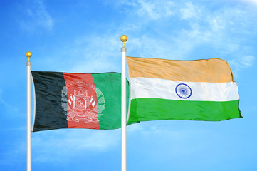 Afghanistan and India  two flags on flagpoles and blue cloudy sky