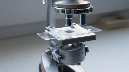 silver microscope in the sunlight from the window