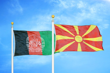 Afghanistan and North Macedonia  two flags on flagpoles and blue cloudy sky