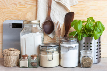 Jars of cereals, kitchen utensils and home plants. Healthy surroundings, comfortable kitchen, sustainable lifestyle concept.