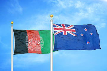 Afghanistan and New Zealand  two flags on flagpoles and blue cloudy sky