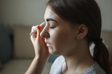 Eyebrows and eyes close-up. The master paints eyebrows with henna, paints with a brush in the salon...