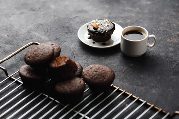 Chocolate cupcakes, muffins with banana, nuts and a Cup of coffee. On a black table and a dark background. Top view, side view. Close-up and medium plan. Space for text.