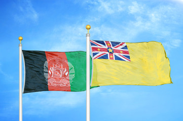 Afghanistan and Niue  two flags on flagpoles and blue cloudy sky