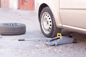 replacement of wheels on the car.Lifting the car with a Jack