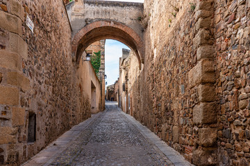 Narrow alley with old stone buildings at Caceres, Extremadura, Spain.