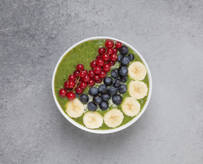 Healthy smoothie bowl with banana, blueberries, kiwi, spinach and red currant. The Breakfast delicious and the view from the top.