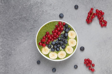 Healthy smoothie bowl with banana, blueberries, kiwi, spinach and red currant. The Breakfast delicious and the view from the top.