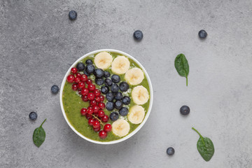 Healthy smoothie bowl with banana, blueberries, kiwi, spinach and red currant. The Breakfast delicious and the view from the top.