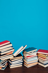 many stacks of educational books for learning preparation for college exams on a blue background