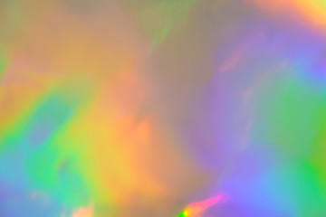 abstract holographic iridescent foil texture background with rainbow colored spots