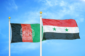 Afghanistan and Syria  two flags on flagpoles and blue cloudy sky