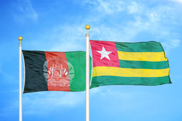Afghanistan and Togo  two flags on flagpoles and blue cloudy sky