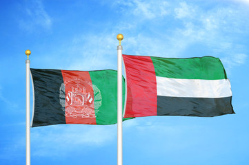 Afghanistan and United Arab Emirates  two flags on flagpoles and blue cloudy sky