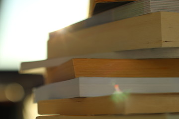 Bücher sind auf dem Tisch gestapelt und das Sonnenlicht wird reflektiert