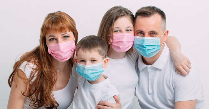 Young Family In Medical Masks During Home Quarantine.