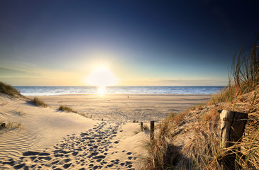 chemin de sable vers la plage de la mer au coucher du soleil