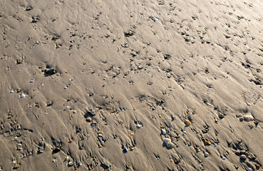 close up of sand on a beach with sun