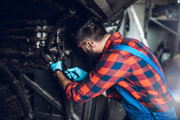 Professional car mechanic working in vehicle repair service.