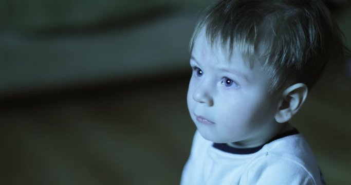Boy watches TV and eats