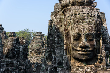 Multiple large faces of the Buddha are carved in to the side of the Unesco World Heritage site of Ankor Thom, Siem Reap, Cambodia