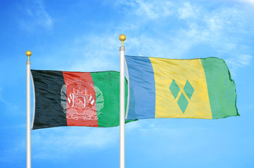 Afghanistan and Saint Vincent and the Grenadines  two flags on flagpoles and blue cloudy sky