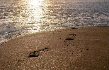 Fototapeta na wymiar footprint erased in the sand with water