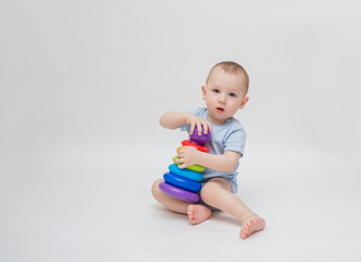 Baby boy on a white background plays in the pyramid. On white background with copy space