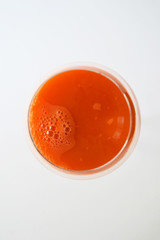 fresh carrot juice in a glass over white