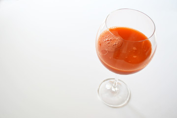 fresh carrot juice in a glass over white