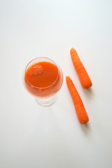 A glass of fresh carrot juice and whole carrots