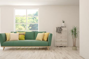 Fototapeta premium White living room with sofa and summer landscape in window. Scandinavian interior design. 3D illustration