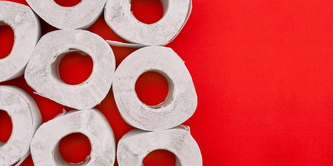 Toilet paper on a red background with copy space. White paper product used for sanitary purposes....