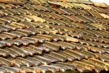 a close up of rustic Mangalore tile sloping roof with moss