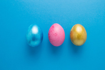 Multi-colored Easter eggs on a blue isolated background. Easter is a bright holiday.