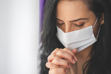 Portrait of woman with surgical mask praying