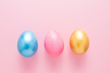 Multi-colored Easter eggs on a pink isolated background. Easter is a bright holiday.