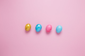 Multi-colored Easter eggs on a pink isolated background. Easter is a bright holiday.