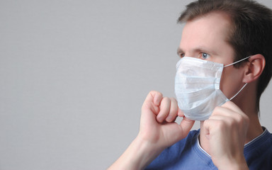 man puts on a medical mask. virus and health concept