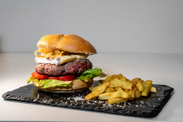 Hamburguer with cheese, tomato, lettuce, onion and chips