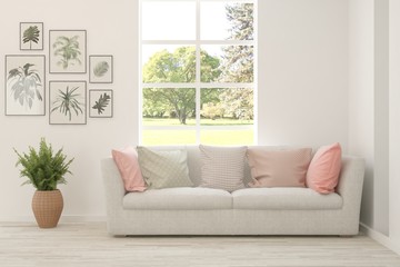 White living room with sofa and summer landscape in window. Scandinavian interior design. 3D illustration