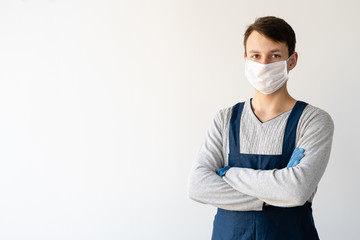 young man is wearing a medical face shield and uniform. Work during a pandemic and quarantine.