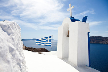 church in oia village santorini greece and greek flag