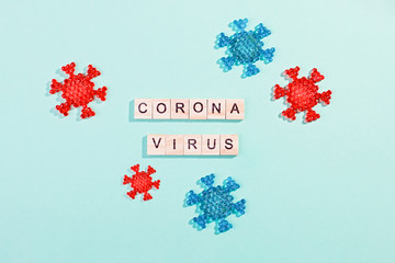 Words corona virus outbreak made of wooden blocks with coronavirus model on blue background, flat...