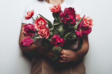 Beautiful Bunch of Peony Style Tulips in the hands of young woman, spring holiday concept, copy space, present for mothers day from kids